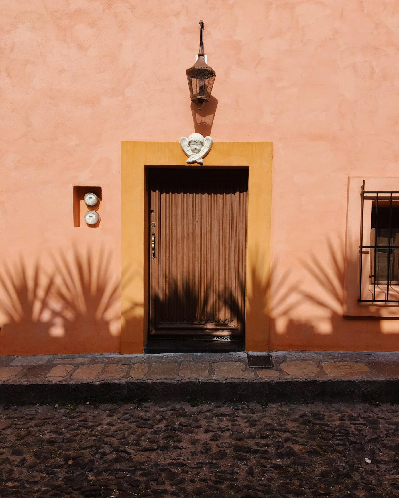 Fachada de casa con medidor de luz junto a la puerta